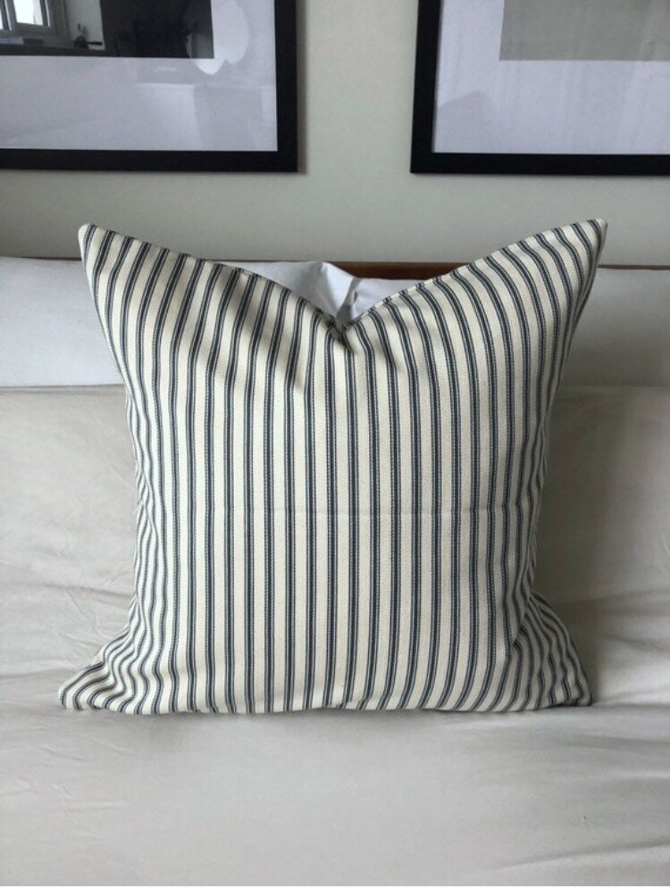 Striped teal pillow on a white bed