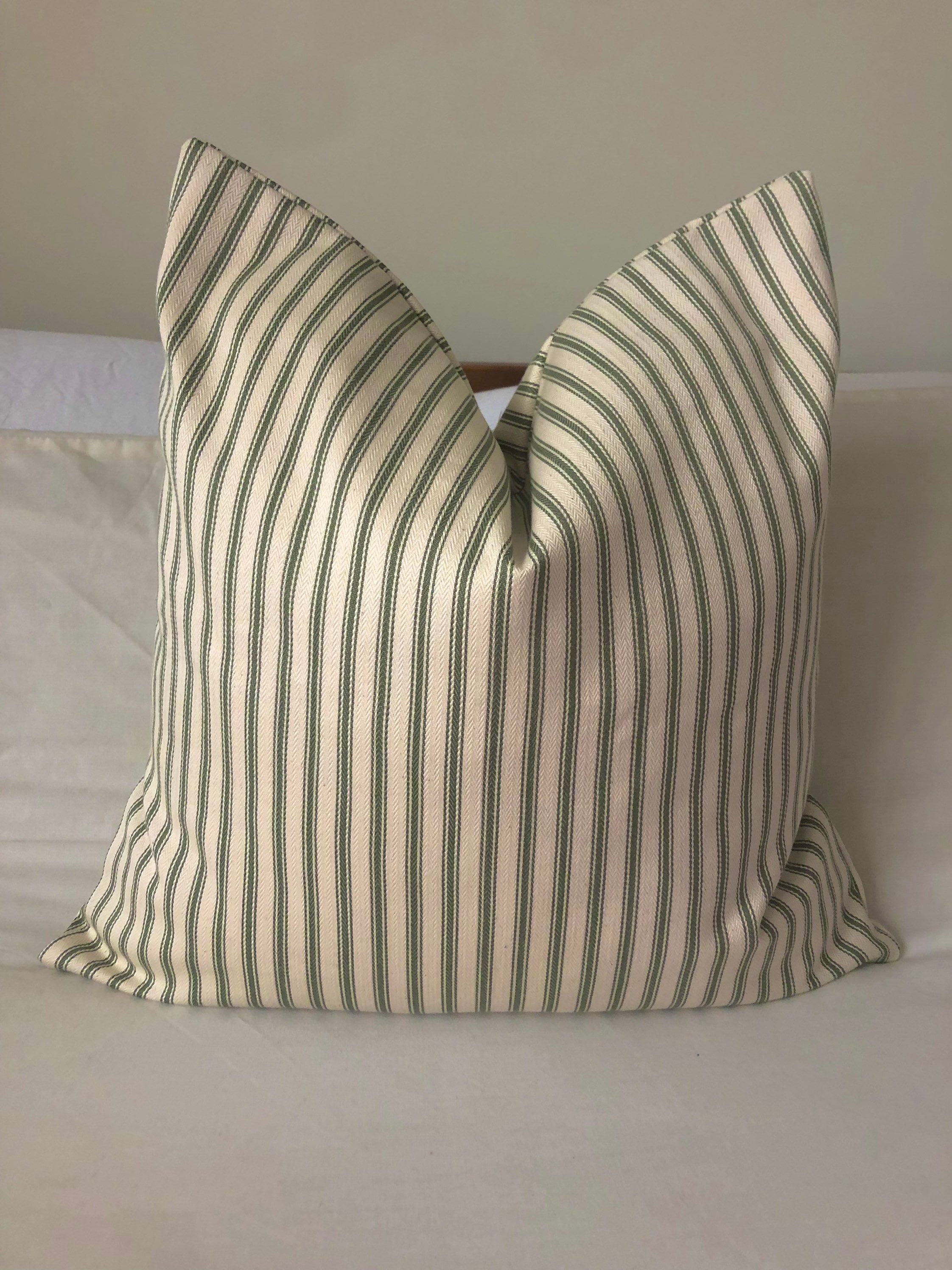 striped olive green pillow on a neutral background