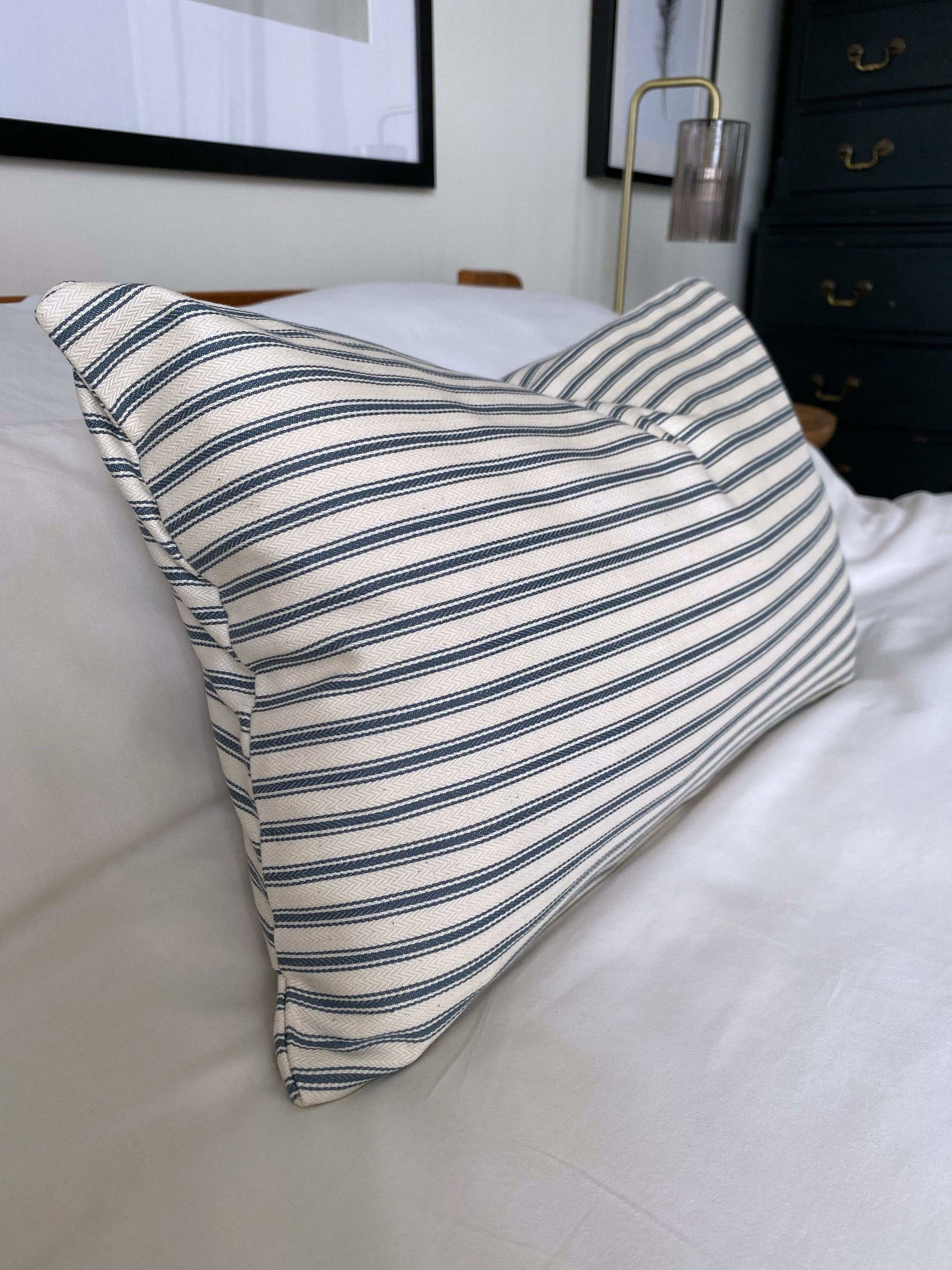 teal Striped pillow on a bed in a bedroom setting